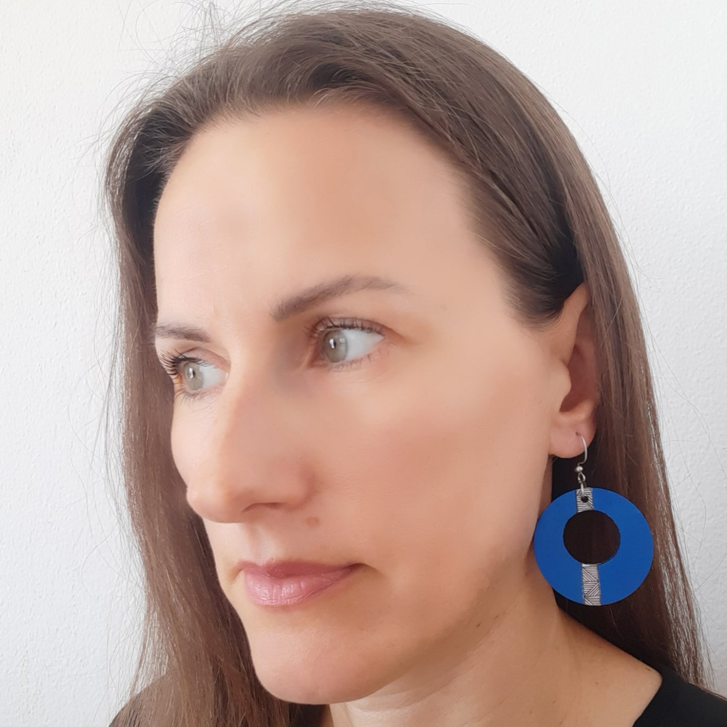 Blue unique hand-drawn wooden earrings in the shape of a circle