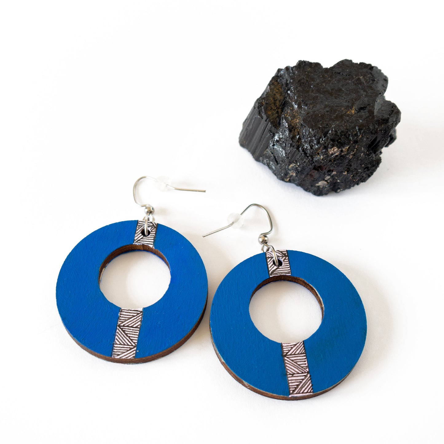 Blue unique hand-drawn wooden earrings in the shape of a circle