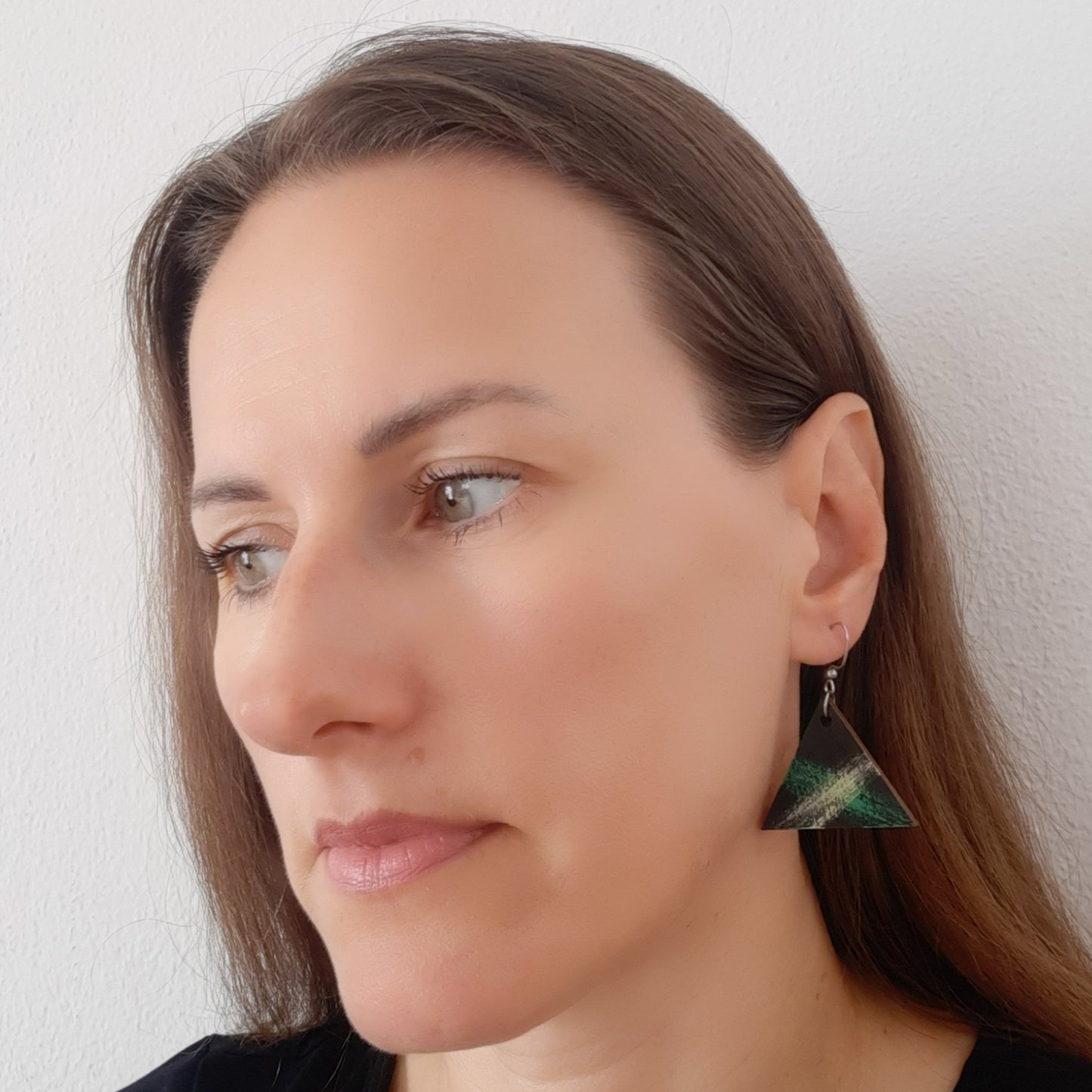 Black wooden earrings in the shape of a triangle with green and yellow details