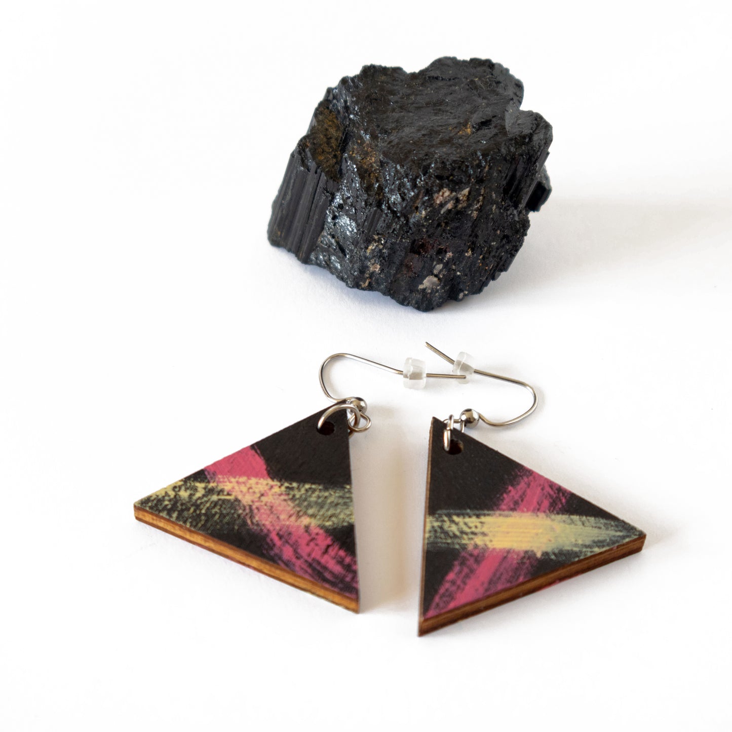 Black triangular wooden earrings with pinkish yellow details