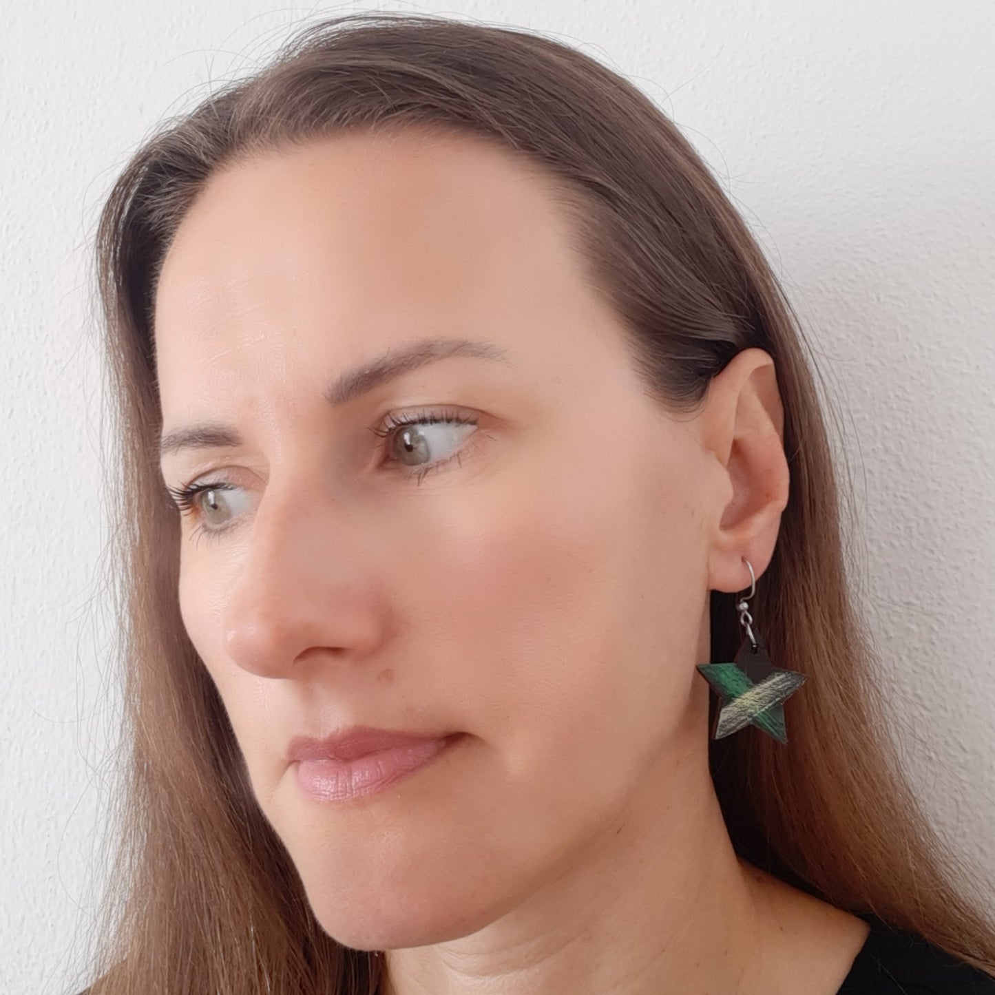 Star shaped black wooden earrings with green and yellow details