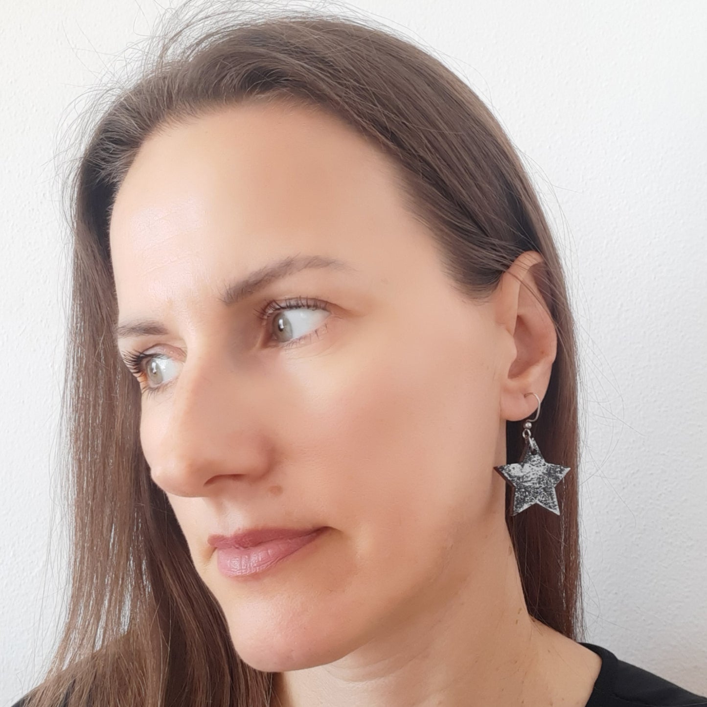 Star shaped black wooden earrings with silver details